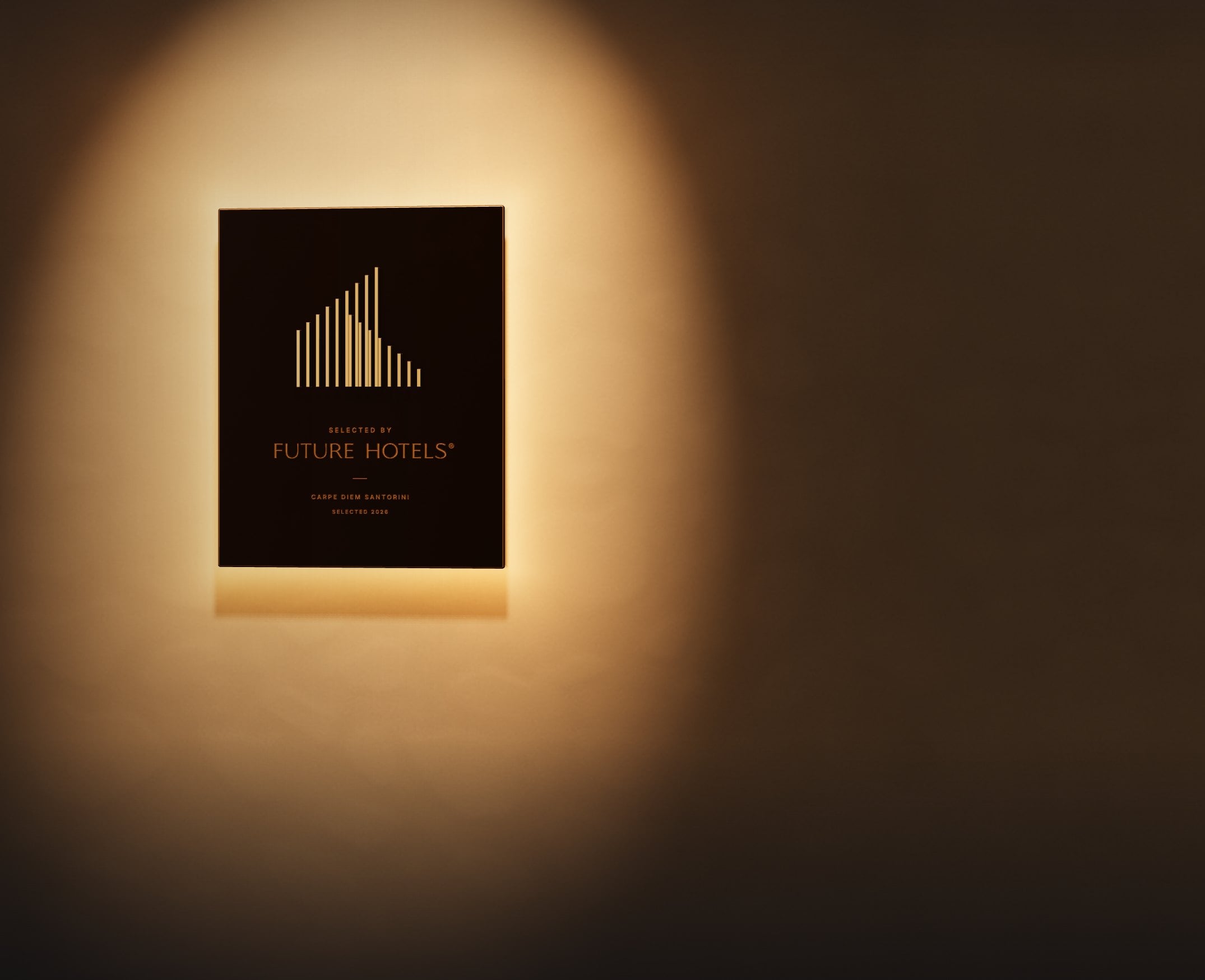The Signature plaque at night, lit from above on a wall.